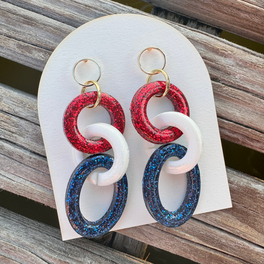 Colorful earrings on a white card with a wooden background
